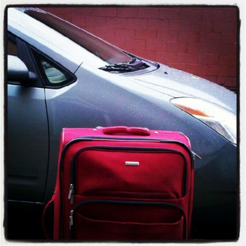 prius with suitcase on a road trip